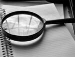 magnifying glass over open notebook